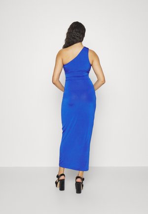Robe maxi bleu sans manches à une épaule, en tissu lisse, silhouette ajustée, longueur au genou, associée à des sandales noires à talons hauts.