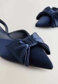 Merenkullan satiinista valmistetut slingback-kengät, joissa on teräväkärkinen muotoilu ja suuri nauha etuosassa. Sileä pinta ja tyylikäs, elegantti muotoilu.
