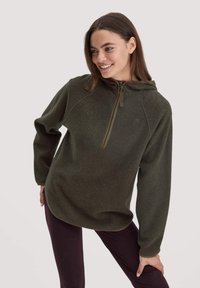 Dunkelgrüner Fleece-Pullover mit einem halben Reißverschluss an der Vorderseite, Kapuze und Raglanärmeln. Besitzt eine weiche Textur und einen abgerundeten Saum.