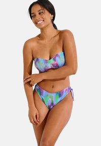 Ensemble de bikini comprenant un haut bandeau et un bas taille haute, conçu avec un motif psychédélique multicolore dans des teintes de violet, vert et bleu.