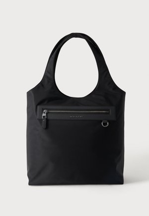 Black tote bag with wide handles, front horizontal zip pocket, small metal ring detail, and subtle Michael Kors logo on the pocket panel.