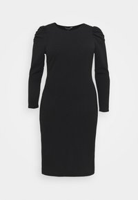 Svart figurnära klänning med långa ärmar, rund halsringning och rynkade axeldetaljer. Tillverkad av ribbat tyg, slät textur, knälång.