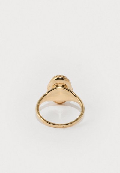 Gold ring with a smooth band and a round, domed top featuring a textured edge, displayed from an overhead angle on a white background.