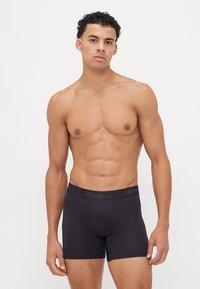 Zwarte katoenen boxershorts met een snug fit, voorzien van een zachte elastische tailleband en minimale naden voor comfort.