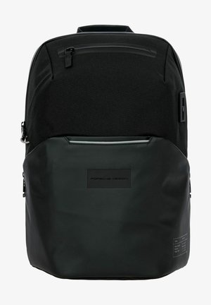 Sac à dos noir avec un dessus en tissu mat et une section inférieure brillante. Présente des zips, une poche avant et un patch logo. Design épuré.