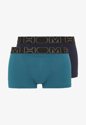 To sæt boxertrunks: et grønt og et marineblåt, begge med sort elastisk talje, der har grå logo tekst. Glat bomuldsstof.