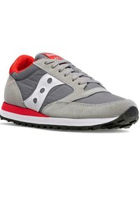 Grijze sportschoen met rode accenten, voorzien van een bovenwerk van suede en textiel, gepolsterde kraag, witte logo en een zwarte rubberen zool met profiel.