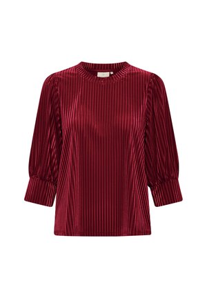 Sarkans ribots blūze ar apaļu kakla izgriezumu un trīs ceturtdaļu pūkainām piedurknēm. Gluda tekstūra ar maigu spīdumu un piegriezums, kas veidots.