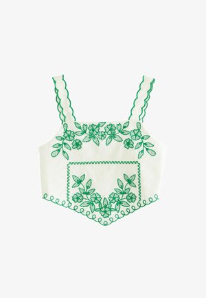 Vit croptop med grön blommönsterbroderi, scallopade axelband och dekorativa kanter. Inkluderar en frontficka med matchande broderi.