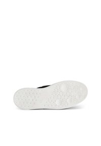 Scarpa nera con suola in gomma bianca flessibile caratterizzata da un motivo a stelle. La suola presenta accenti circolari per una maggiore presa.