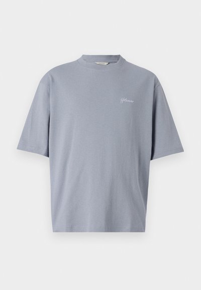 Siva bombažna majica s krojem okroglega ovratnika in kratkimi rokavi. Na prsih ima majhen, bel vezen logotip. Preprost, sproščen dizajn.