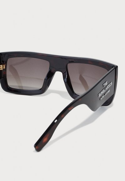Ochelari de soare cu rame maro tortoiseshell și lentile cu gradient. Design cu un cadru unghiular. Include o balama aurie și un logo pe braț.