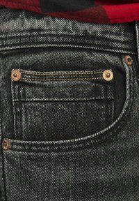 Bolso de jeans de mezclilla negra con costuras doradas, que presenta un pequeño bolsillo superior y remaches de cobre, destacando una superficie texturizada.
