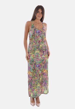 Mujer que lleva un vestido maxi sin mangas, multicolor con estampado de cachemira, con escote redondo y tacones altos en tono nude, de pie sobre un fondo claro.