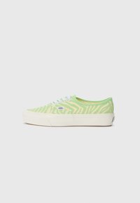 Lime green canvas sneakers with a zebra pattern, white eyelets, and a cream rubber sole. Features Vans logo on the outer side.