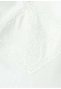 Tissu blanc avec broderie florale et bordure en dentelle formant une forme de losange au centre.