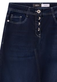 Falda de mezclilla de Cecil, azul oscura con una textura suave. Cuenta con cierre de cinco botones, bolsillos frontales y costuras blancas en contraste.