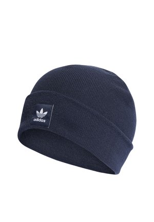 Navy blue knit beanie with a folded cuff and a rectangular white label featuring the Adidas logo. Soft texture, simple ribbed design.