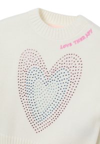 White knitted sweater featuring a large heart design made of multicolored rhinestones. Accented with "LOVE THERAPY" in pink embroidery.