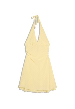 Robe jaune à col dos nu avec un profond décolleté en V et une jupe évasée, avec de subtiles rayures diagonales et une fermeture à nouer au niveau du cou.