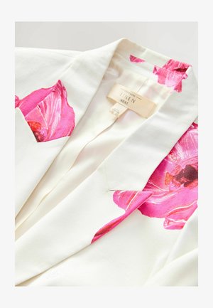 Leinenblazer mit großen rosa Blumenmotiven auf den Schultern und Taschen, in einer cremefarbenen Grundfarbe und mit glatter Textur.