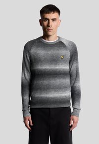 Grauer gerippter Pullover mit einem Gradientenmuster, runder Halslinie und langen Ärmeln. Ein kleines gelbes Logo befindet sich auf der Brust.