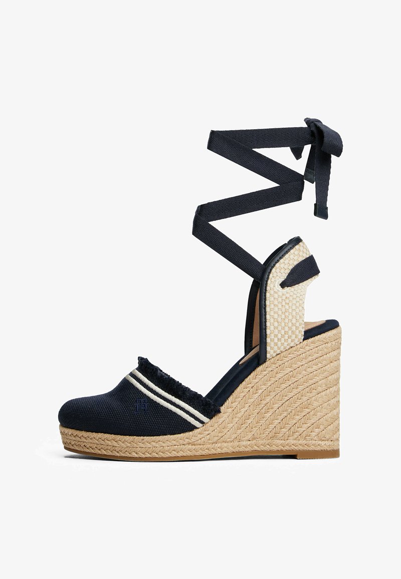 Sandalo wedge in tela blu con tacco espadrille testurizzato, strisce decorative, punta aperta e lacci incrociati alla caviglia. Accenti in fibra naturale.