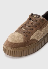 Sneaker in suede marrone con tomaia in lana beige, punta rotonda, superficie testurizzata e suola in gomma marrone con scanalature verticali e design con lacci.