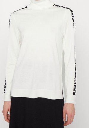 Witte coltrui met lange mouwen en zwarte strepen, met de tekst "DKNY" langs beide mouwen.