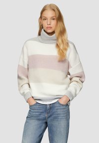 Chunky gebreide Coltrui in wit, lichtroze en grijze strepen. Gevoerde stof met een relaxte pasvorm, gecombineerd met lichtblauwe jeans.