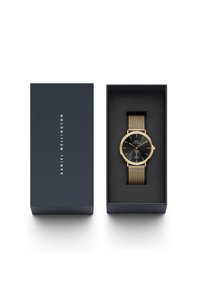 Melna pulksteņa ar zelta akcentiem, kas aprīkots ar sietu siksniņu, tumšā kaste, kas izklāta ar melnu putuplasta materiālu. Zīmola nosaukums "Daniel Wellington" ir iegravēts.