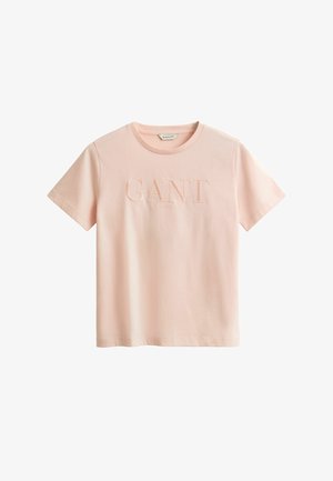 Vaaleanpunainen puuvillapaita, jossa on pyöreä kaula-aukko, lyhyet hihat ja kohopainettu "GANT" -logot edessä. Sujuva rakenne ja rento istuvuus.