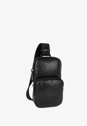 Schwarze Leder-Slingtasche mit zwei Reißverschlussfächern, verstellbarem Tragegurt und glatter Textur. Kompaktes Design, das sich für den täglichen Gebrauch eignet.