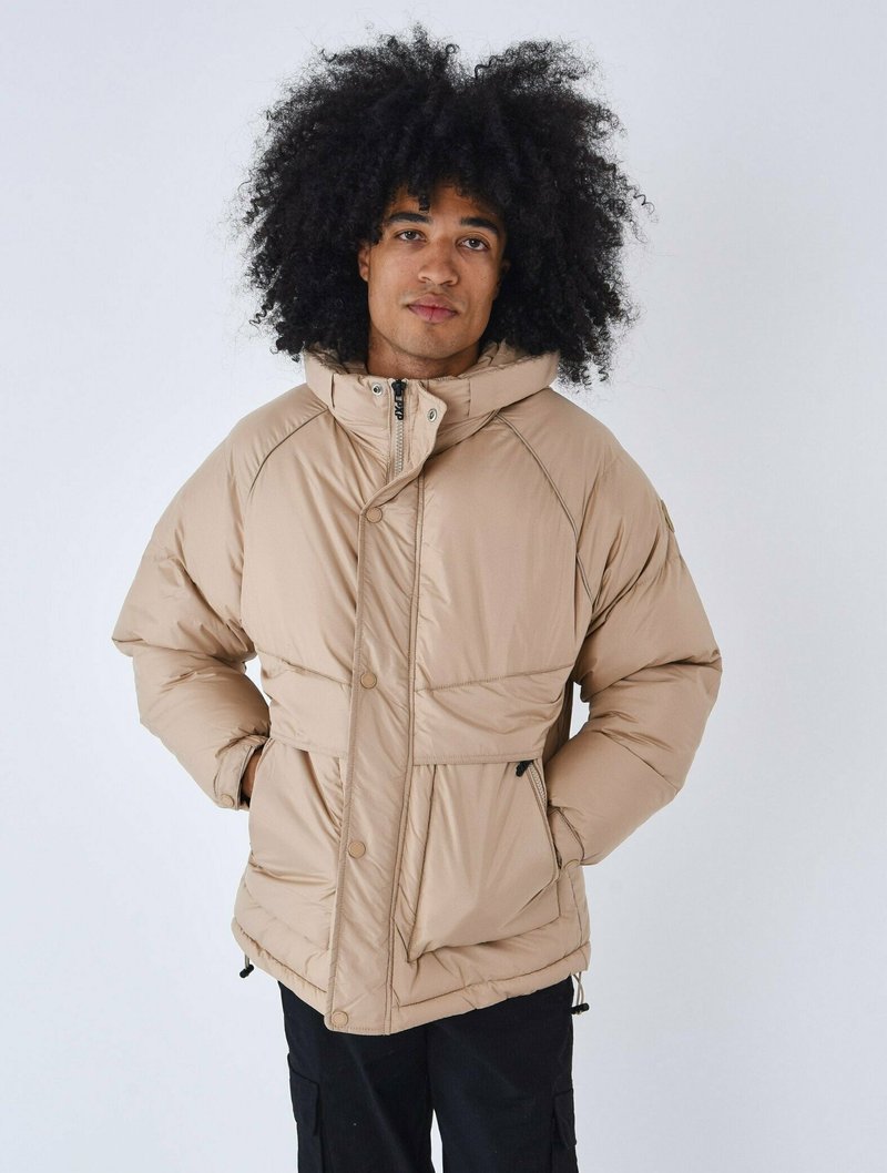 Giacca imbottita beige con colletto alto, cuciture a vista e bottoni frontali. Presenta tasche laterali e cordino regolabile all'orlo.
