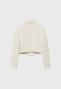 Veste courte en lin beige clair avec manches longues et col cranté. Présente un design épuré et minimaliste ainsi qu'un tissu texturé.