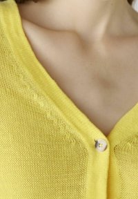 Gelber Strickcardigan mit V-Ausschnitt, ausgestattet mit einer einzigen Knopfverschluss und subtilen Strukturdetails entlang der Kanten.