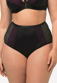 Culotte taille haute noire avec des accents en panneaux transparents en rayures violettes et grises, présentant une texture lisse et des bords sans couture.