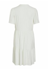 Robe blanche à manches courtes avec un col rond, une taille froncée, une jupe à étages et un motif subtil en œillets, vue de dos.