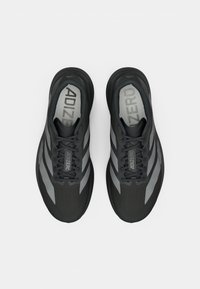 Černé sportovní boty s lehkým designem, zdobené šedými akcenty, hladkým povrchem a šněrováním. Na vložce je vytištěno "ADIZERO".