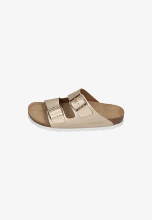 Beige leather slide sandal with two adjustable straps featuring metallic buckles. Cork footbed and white rubber outsole.
