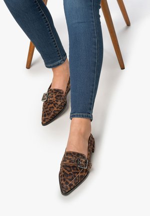 Leopard print flats with pointed toes, a decorative silver buckle, and a low heel, paired with dark blue skinny jeans.