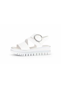 White sandals with two wide cross straps and a circular silver accent, featuring a thick white sole with a ridged pattern.