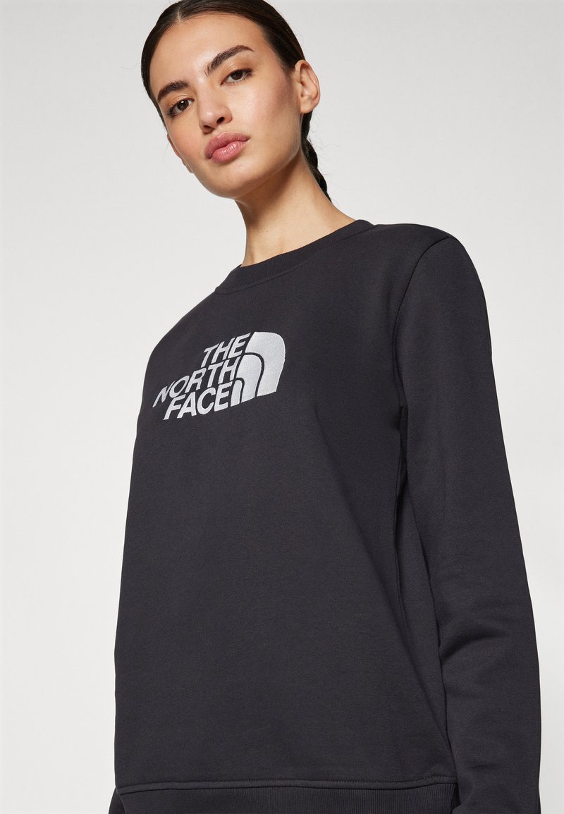 Donkergrijze sweatshirt van een katoenmix, met een groot wit geborduurd logo op de voorkant, ronde halslijn en lange mouwen.