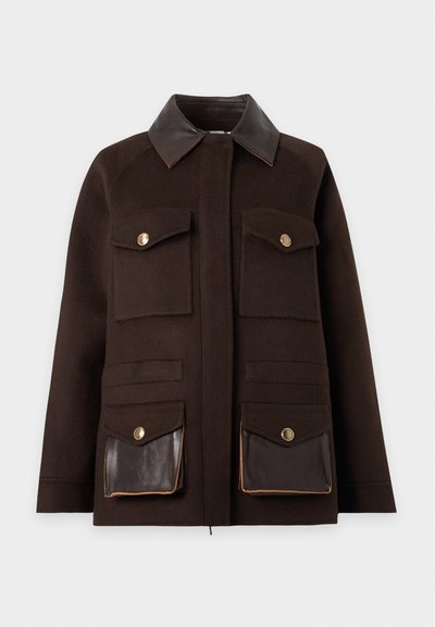 Veste marron foncé avec quatre poches avant, deux avec rabats à boutons et deux avec des détails contrastants en cuir sombre, et un col en cuir sombre.