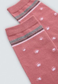 Calcetines rosas con puños a rayas grises y blancas. Presentan un diseño texturizado con pequeñas huellas de patas blancas en toda la superficie.