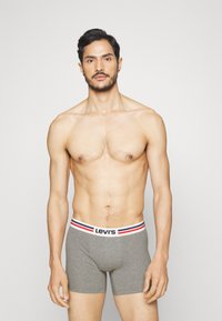 Sz�ürke boxeralsó fehér, piros és kék csíkos elasztikus derékpánttal, amelyen a "Levi's" logo látható. Simább, testhez simuló dizájn.
