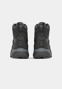 Botas de caminhada isoladas pretas com superior em tecido texturizado, colarinho acolchoado e sola de borracha cinza, com suporte reforçado para o calcanhar e biqueira.