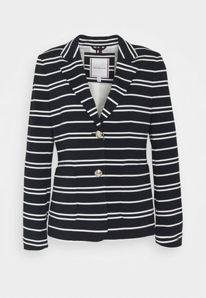 Blazer blu navy con righe bianche, caratterizzato da un colletto a punte, due bottoni dorati e tasche frontali. Tessuto texturizzato con vestibilità su misura.