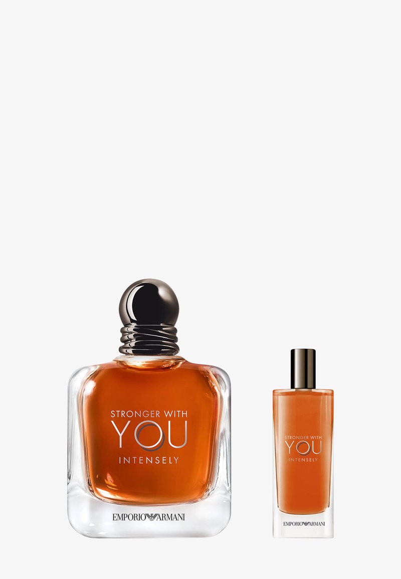 Amber-colored glass perfume bottles, one large with a rounded black cap and one smaller, both labeled "Stronger With You Intensely."