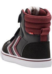 Høye sneakers i svart lær og burgunder fløyel, med hvite og maroon aksenter, polstret krage og borrelåsrem.
